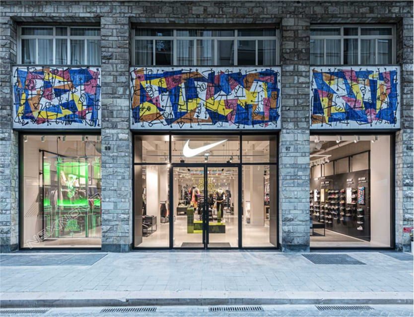 Прозрачный экран в витрине магазина Nike на каменном фасаде